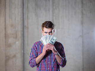 Image showing business man displaying a spread of american dollar cash money