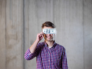 Image showing business man holding american dollars banknote over the eyes