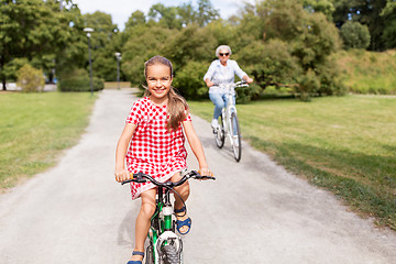 Image showing grandmother and granddaughter cycling at park