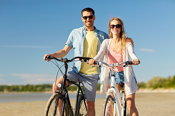 Image showing happy young couple riding bicycles at seaside