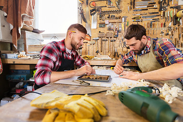 Image showing carpenters with tablet and blueprint at workshop