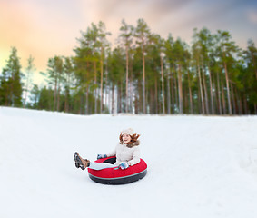 Image showing happy teenage girl sliding down hill on snow tube