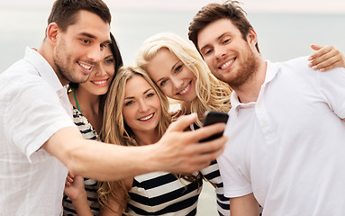 Image showing happy friends taking selfie on summer beach