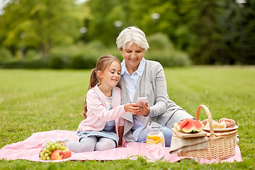 Image showing grandmother and granddaughter with cell at park