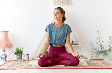 Image showing woman meditating in lotus pose at yoga studio