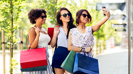 Image showing women with shopping bags taking selfie in city