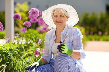 Image showing senior woman with garden pruner and flowers