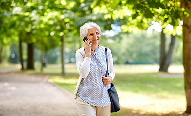 Image showing senior woman calling on smartphone in summer park