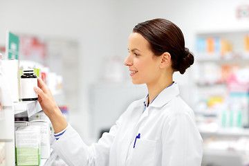 Image showing happy female apothecary with drug at pharmacy