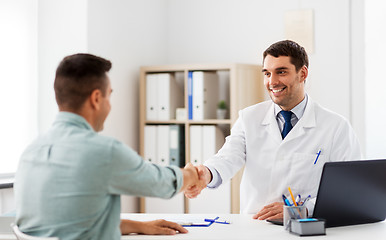 Image showing doctor and male patient shaking hands at hospital