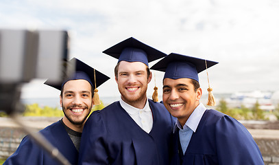 Image showing happy male students taking picture by selfie stick