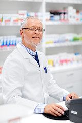 Image showing senior apothecary at pharmacy cash register