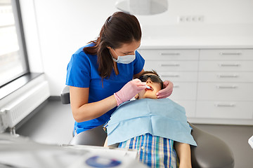 Image showing dentist checking for kid teeth at dental clinic