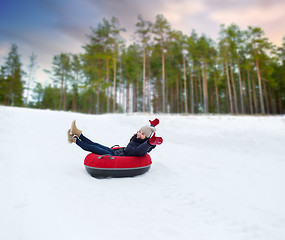 Image showing happy teenage girl sliding down hill on snow tube