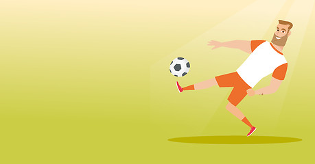 Image showing Young caucasian soccer player kicking a ball.