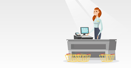 Image showing Cashier standing at the checkout in a supermarket.