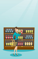 Image showing Woman holding shopping basket and bottle of sauce.