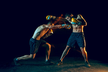 Image showing Male boxer boxing in a dark studio