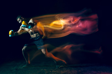 Image showing Male boxer boxing in a dark studio