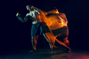 Image showing Male boxer boxing in a dark studio