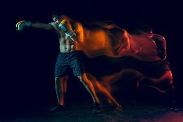 Image showing Male boxer boxing in a dark studio