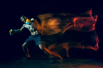 Image showing Male boxer boxing in a dark studio