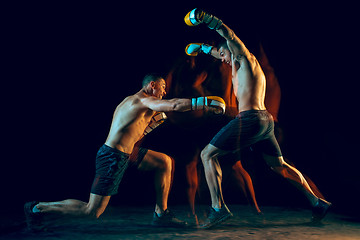 Image showing Male boxer boxing in a dark studio