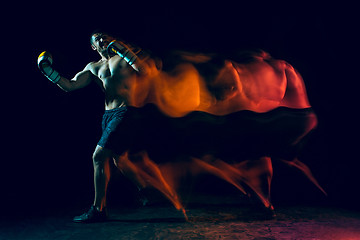 Image showing Male boxer boxing in a dark studio