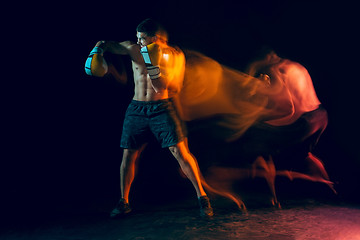 Image showing Male boxer boxing in a dark studio