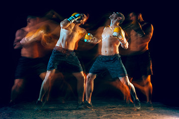 Image showing Male boxer boxing in a dark studio