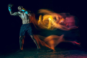 Image showing Male boxer boxing in a dark studio