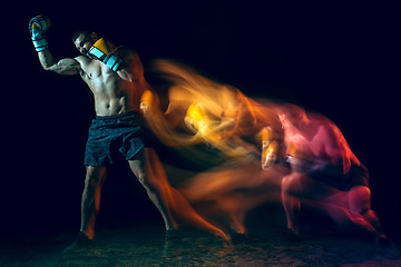 Image showing Male boxer boxing in a dark studio