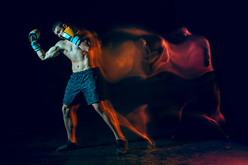 Image showing Male boxer boxing in a dark studio