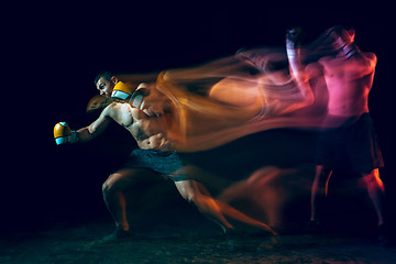 Image showing Male boxer boxing in a dark studio