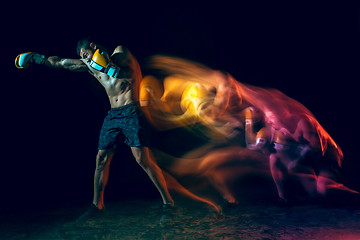 Image showing Male boxer boxing in a dark studio