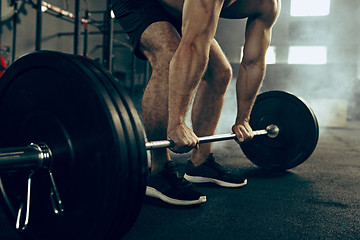 Image showing Fit young man lifting barbells working out in a gym