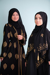 Image showing two hijab muslim woman on cyan background