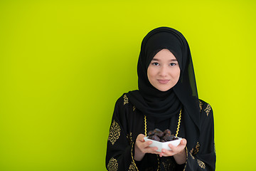 Image showing modern muslim woman holding a plate of dates in ramadan kareem o