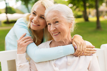 Image showing daughter with senior mother hugging on park bench