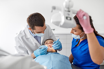 Image showing dentist checking for kid teeth at dental clinic