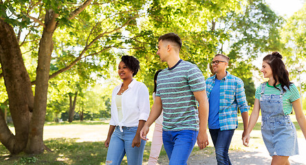 Image showing happy international friends walking in park