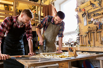 Image showing carpenters working with wooden board at workshop