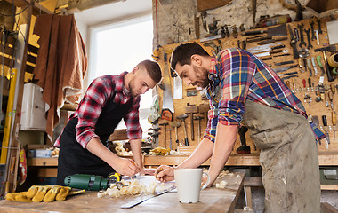 Image showing carpenters with ruler and blueprint at workshop