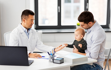 Image showing father with baby and doctor at clinic