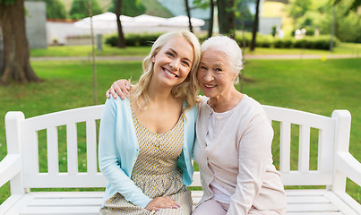 Image showing daughter with senior mother hugging on park bench