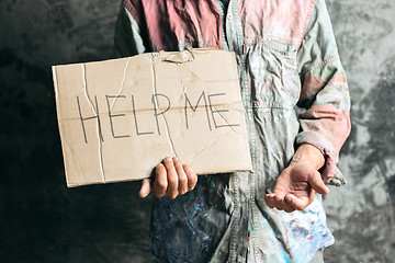 Image showing Male beggar hands seeking money on the wooden floor at public path way