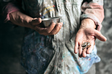 Image showing Male beggar hands seeking money on the wooden floor at public path way