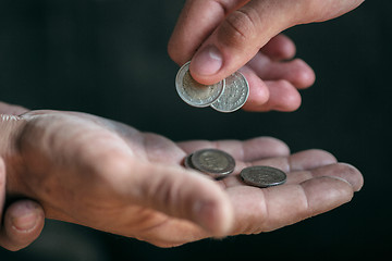 Image showing Male beggar hands seeking money on the wooden floor at public path way