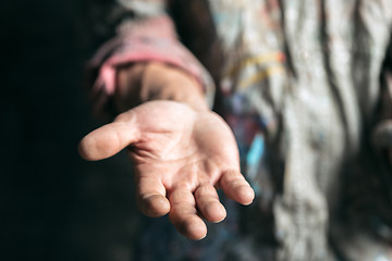 Image showing Male beggar hands seeking money on the wooden floor at public path way