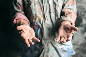 Image showing Male beggar hands seeking money on the wooden floor at public path way